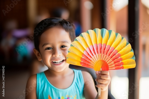 A smiling child holding a colorful fan, signifying the creativity and joy of Garangao celebrations, creativity with copy space