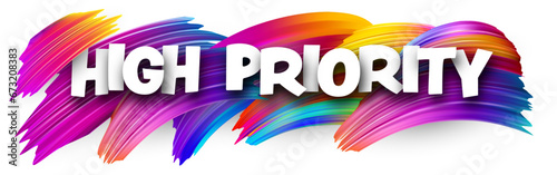 High priority paper word sign with colorful spectrum paint brush strokes over white.
