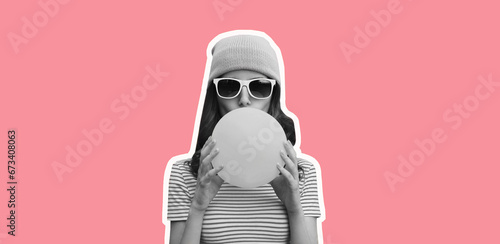 Fashionable portrait of stylish cool young woman inflating chewing gum wearing pink hat on pink studio background