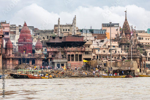 View of the river Ganges with its boats, people and sacred water of Varanasi in India. Manikarnika Ghat