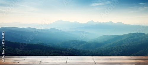 In the misty morning landscape you can admire a wooden table against the backdrop of a blurred mountain view The cool sensation in blue hues adds to the overall ambiance