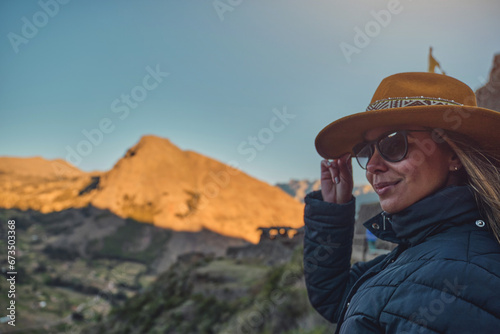 traveler hipster girl in hat with backpack exploring Pisac Archaeological of Peru.