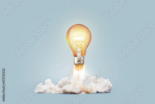 Creative light bulb rocket with blast and smoke takes off on a blue background, concept. Successful launch and development, creative idea. Think differently. Creative generator. Smart and thinking