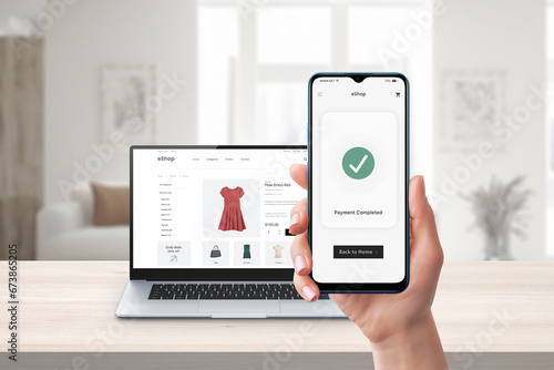 Phone online payment. Laptop and e-commerce website in background. Digital transaction showcasing seamless online shopping and secure electronic payments