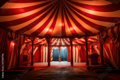 Inside interior circus tent, arena features stage and ring beneath red and white striped top, setting stage for an exciting and mesmerizing show