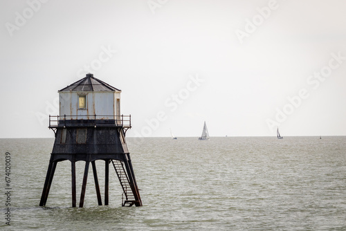 Old lightouse in the sea, Dovercourt low lighthouse, built in 1863 and discontinued in 1917 and restored in 1980 the 8 meter lighthouse is still a iconic sight, with sailing boats sailing past