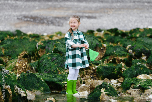 Girl in rubber boots catches crabs with fishing nets