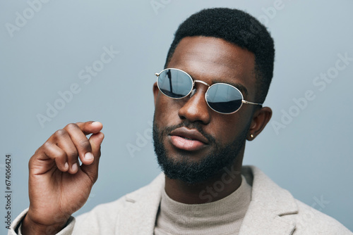 Cheerful african man wearing glasses jean jacket having white snow smile pointing fingers aside at copy space for your text advertisement, advertise teeth whitening or eyewear store good offer concept