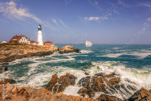Boat sailing by the Portland Head Lighthouse in Maine