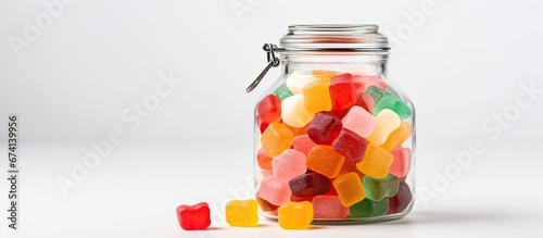 Colorful jelly candies are displayed in a glass jar against a white background
