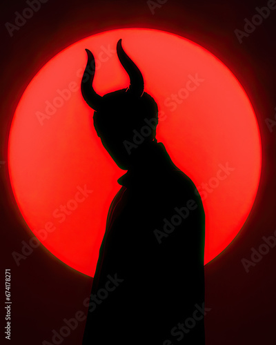 silhouette of a devil with horns on red circle background