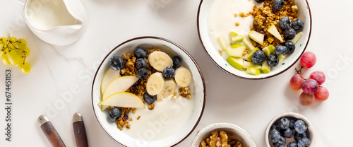 Weight loss, healthy lifestyle and eating. Two healthy breakfast bowl with ingredients granola fruits Greek yogurt and berries on white background top view