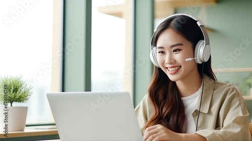 Beautiful Young Asian woman at home sitting on the sofa while using laptop and headphone at home