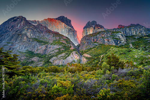 Magical colorful sunrise at major peaks, standing high towers teeth, and waterfall nearby surrounded by wet austral forests in Torres del Paine National Park, Patagonia, Chile, details