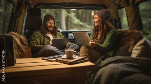 Man and woman with dog traveling together on transport - Freelance nomad concept with hippie people on car romantic trip working at laptop pc in relax moment