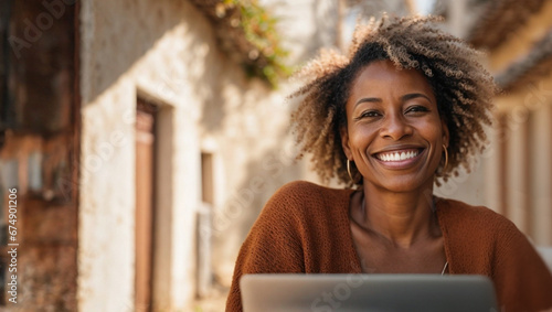Beautiful African American mature businesswoman working on laptop, freelance woman with computer on table in comfortable space, concept of nomadic life and remote work, space for text