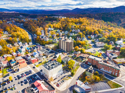 old town of Cumberland in Maryland in the fall. houses, parking lots with cars, and churches among yellowed trees and hills