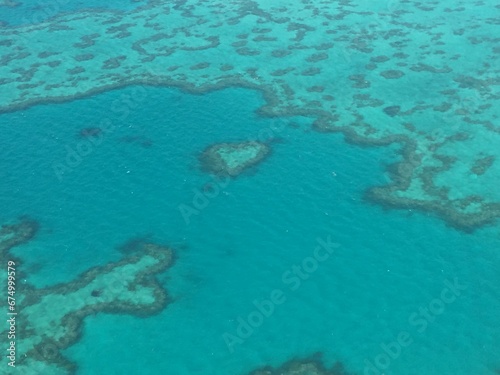 Aerial view of heart-shaped reef under the clear blue ocean water