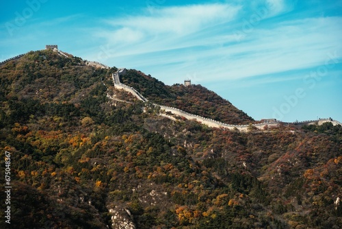 the great wall of china and its surrounding mountains with trees