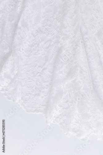 Chic white wedding background. Soft pleats of lace vintage fabric. Floral ornament. Vertical view. A copy of the space. Design mockup.