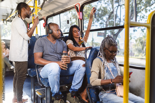 Multiracial passengers inside the bus on an urban route.
