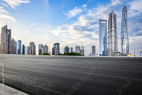 Asphalt road and city buildings skyline background in Shanghai