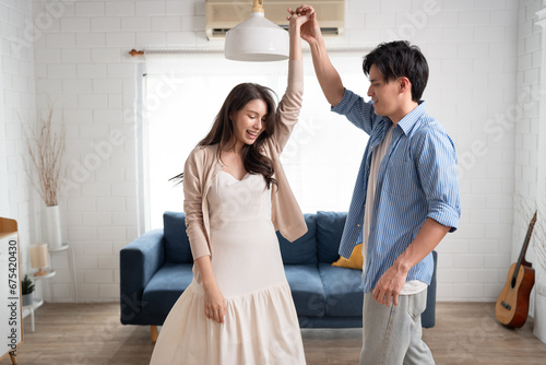 Happy Asia beautiful couple dance at home