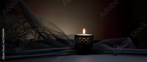 Condolence, grieving card, loss, remembrance. Candle on a dark table burning, symbole of mourning of a loved one. Black net fabric and dark background. Card for words of support and comfort. 