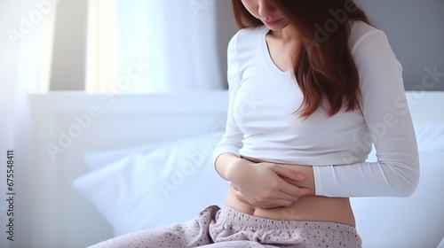 woman with pain holds her hands protecting over her stomach 