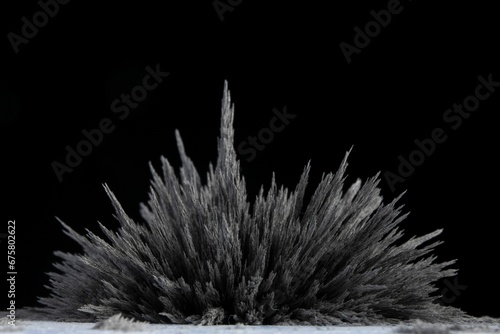 Reaction of iron dust to a magnetic field of a strong neodymium magnet on a black background