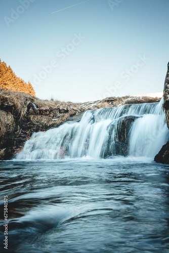 Vertical shot of a waterfall cascading over rocks