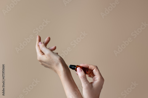 Woman applying natural rollerball aroma oil on her wrist close up 
