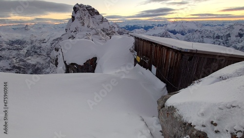 Die eingeschneite Biwakschachtel Notunterkunft am Watzmann Hocheck in den Berchtesgadener Alpen im Winter kurz vor Sonnenuntergang
