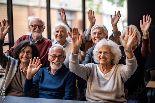 A mixed ethnic group of retired elderly senior citizens adults raising hands with questions with a smile