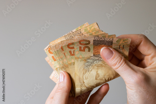 Mão segurando dinheiro, notas de Real Brasileiro
