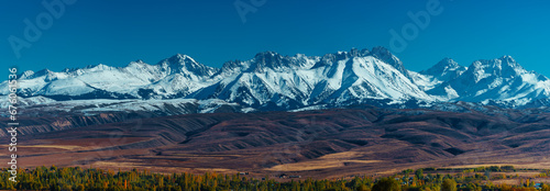 Picturesque panorama with snowy high mountains in autumn