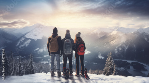 A family of skiers looks at the snow-capped mountains at a ski resort, during vacation and winter holidays.