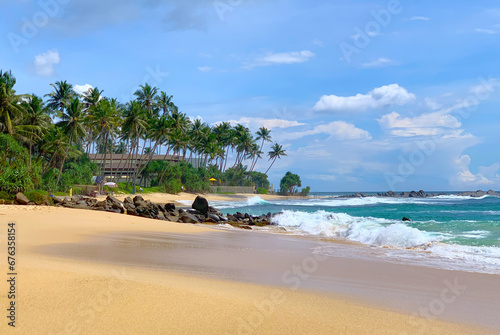 View of a beautiful sandy beach with palm trees, Indian Ocean coast in Sri Lanka, Unawatuna