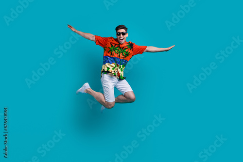 Full body photo picture of funky flying air plane wings hands guy brunet wear sunglasses travel abroad isolated on blue color background
