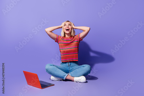 Full body length photo of young amazed girl shopaholic look black friday offers on aliexpress website isolated over violet color background