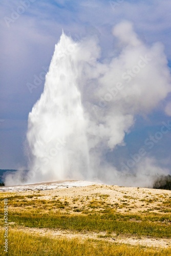 Vertical shot of the eruption of geyser Old Faithful in Yellowstone National Park.