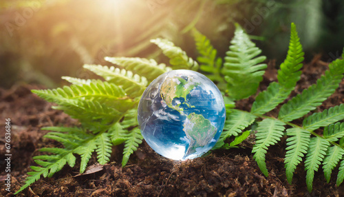 crystal earth on soil in forest with ferns and sunlight environment save clean planet ecology concept earth day banner with copy space