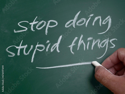 Stop doing stupid things, word text written on chalkboard, motivational inspirational life quotes