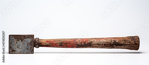 In a vintage backdrop an isolated wooden tool with a black metal handle and a worn rusty iron blade sits on a white background representing the old industrial steel work with a touch of red