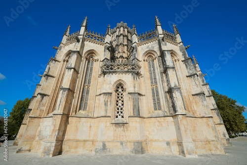 Klasztor Batalha, Portugalia. Monumentalne, sakralne dzieło architektoniczne. Perspektywa, linie zbieżne, jaste, piaskowe, strzeliste wieżyczki. na tle granatowego nieba