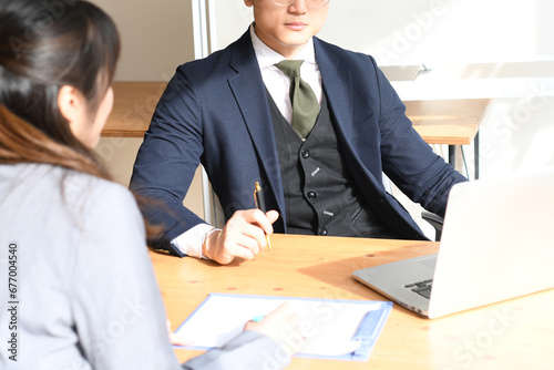 オフィスで会話するアジアの男性と女性のビジネスマン
