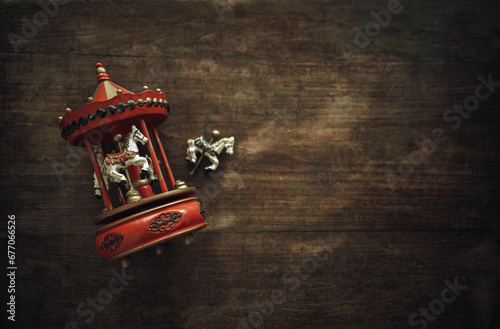 Antique toy carousel with horses. A vintage wooden toy is lying on the table. A clockwork musical carousel.