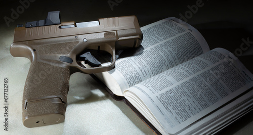 Bible open to the book of Luke with pistol on top