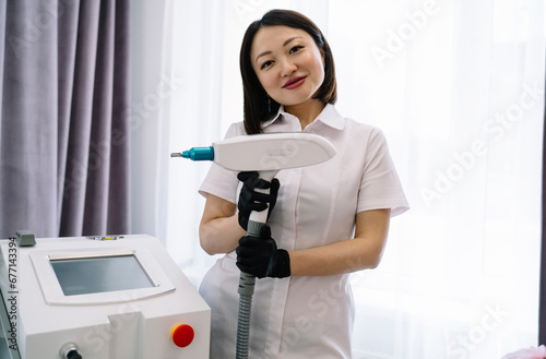 Smiling female cosmetologist with YAG laser