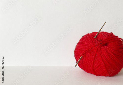A skein of red yarn for hand knitting on a white background. Empty space for text, close-up, mockup